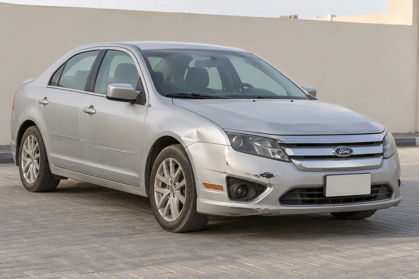 Used early-2010s Fusion-style Ford sedan with bumper scrapes, a small fender dent and light door scratches at a UAE assessment forecourt