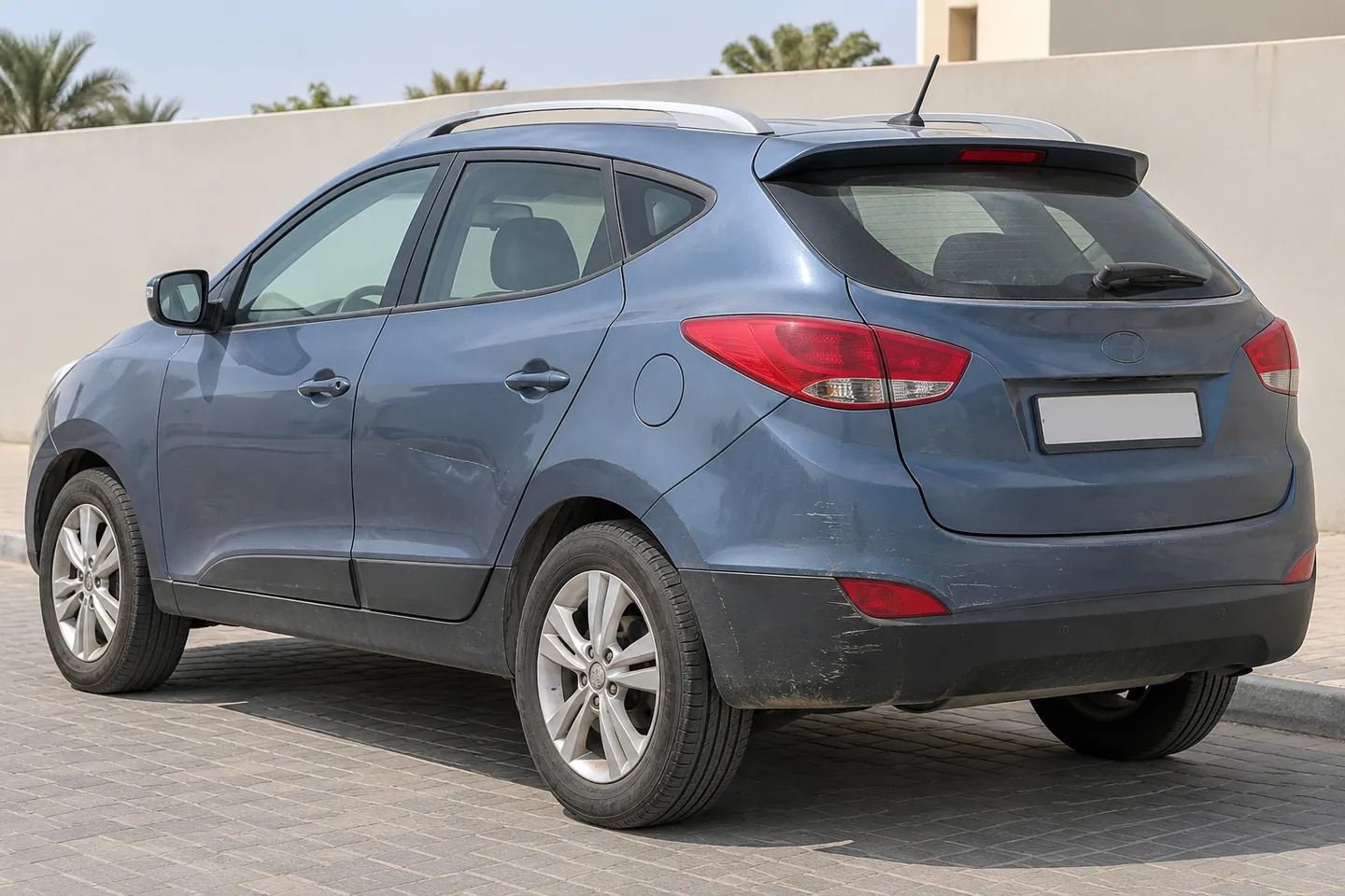 Used early-2010s Tucson-style Hyundai SUV with light rear bumper scuffing, lower-panel scratches and a shallow door dent