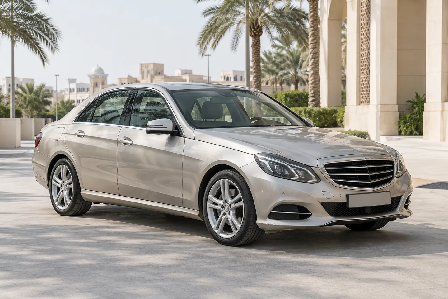 Champagne-silver E-Class-style Mercedes-Benz sedan with modest bumper wear at a quiet UAE inspection forecourt
