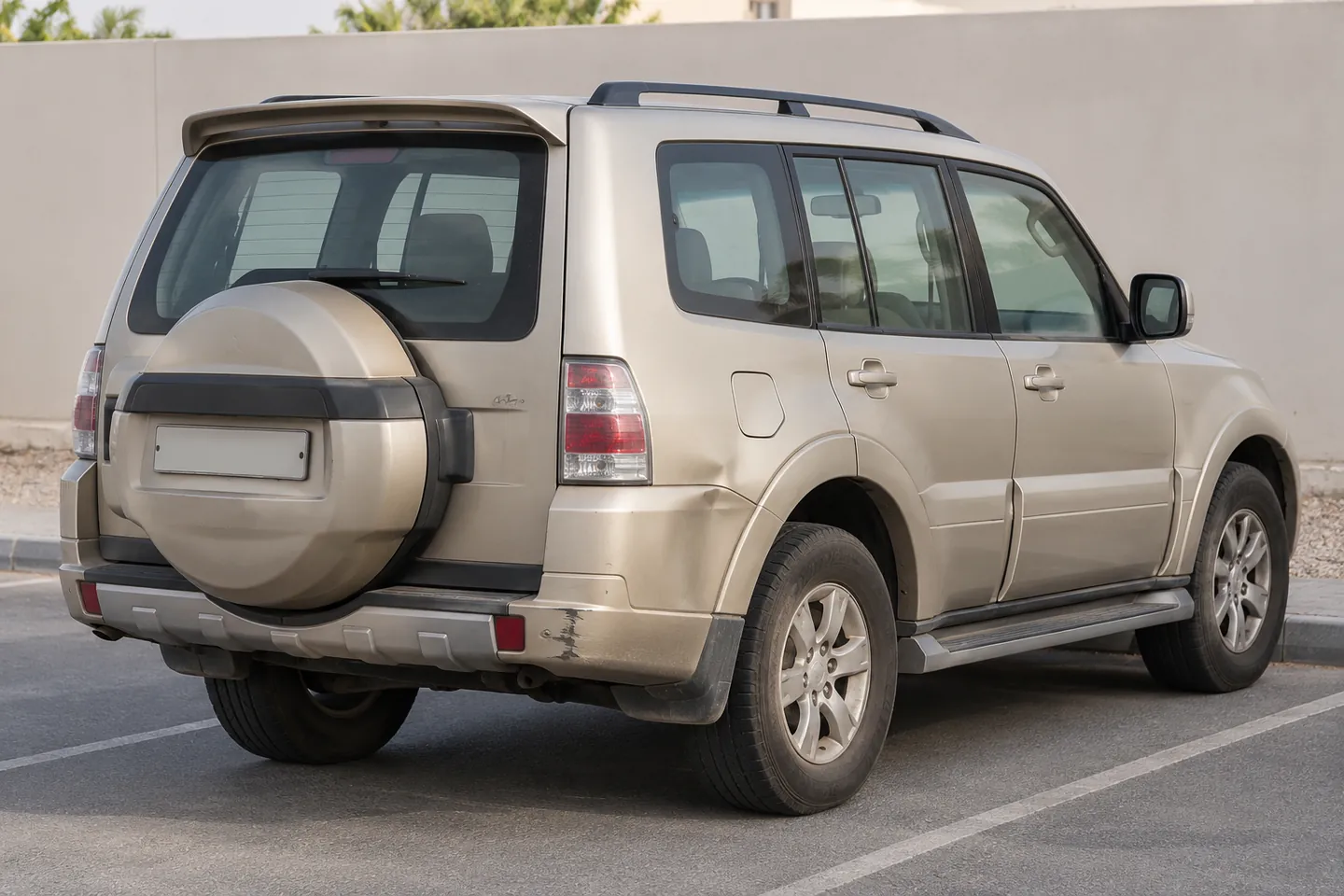 Used 2013 Pajero-style Mitsubishi SUV with rear bumper scuffs, a shallow quarter-panel dent and dusty paint