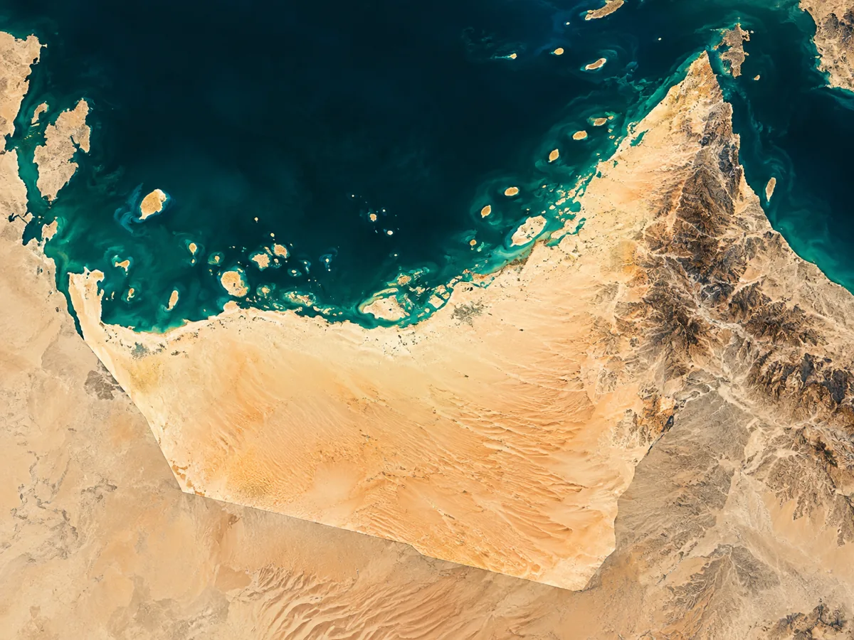 Satellite-inspired editorial artwork of UAE desert terrain, emerald Gulf waters and the eastern mountain landscape
